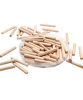 Premium Hardwood Birch Dowel Pins 120 Pieces One Quarter X Two Inch Fluted Joinery Rods Smooth Finish in a bowl, scattered on a surface.
