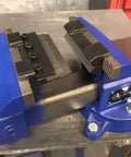 Close-up of a blue 4 Inch Vise Mount Press Brake Bender Attachment for Sheet Metal Cross Slide, mounted on a workbench.