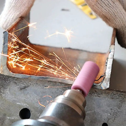 Rotary Tool Grinding Stone Set With One Eighth Inch Shank Aluminum Oxide Bits in use on metal surface, sparks visible