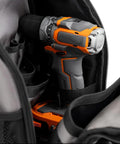 Pro Grade Sling Pack Tool Bag With 24 Pockets Dual Handles Adjustable Strap holding drill inside, Grey.