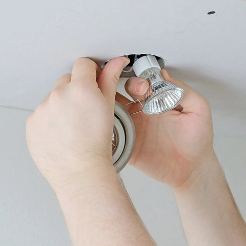 Person installing Six Pack GU10 35W Halogen Bulbs 120V Dimmable Warm White 2700K 380 Lumens in recessed lighting fixture