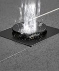 Drop Down Square Pop Up Floor Drain With Matte Black Chrome Cap And Odor Locking Grille For Bathrooms showing water flow.