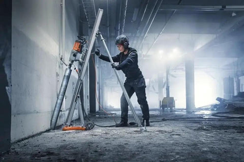 Worker using Straight Up Kickass Core Drill And Stand With 4.29 Hp Motor Three Speed Gears in a concrete environment.