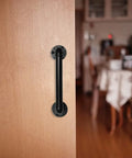 Industrial Pipe Door Pull Handle 12 Inch Black Rustic Grab Bar on wooden door indoors