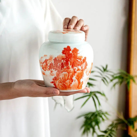Top Tier Ceramic Tea Canisters Set For Loose Tea Leaves And Coffee Beans, Slick Airtight Storage Jars in hand with floral design.