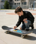 Young skater decorating a Blank Skateboard Decks 31 By 8 Inch Four Pack 7 Layer Maple Double Tail Board with art in a skatepark.