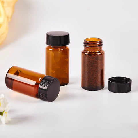 15 Piece Kit Of 10Ml Amber Glass Sample Vials With Black Screw Caps And Pe Liners, 0.34 Oz Tiny Travel Flasks For Essential Oils Perfume Lab Reagents Zero Sweat Spills Badass Reliable Build - three vials standing upright on a white surface.