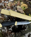 Desert Tan Fixed Blade Outdoor Knife With 4.1 Inch Stainless Steel Blade resting on tree stump