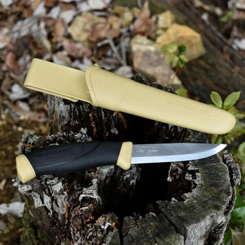 Desert Tan Fixed Blade Outdoor Knife With 4.1 Inch Stainless Steel Blade resting on tree stump