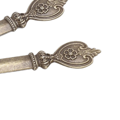 Close-up of decorative handles on Five Piece Retro Envelope Opener Set Zinc Alloy Letter Openers For Quick Mail Opening Sword Shaped Design