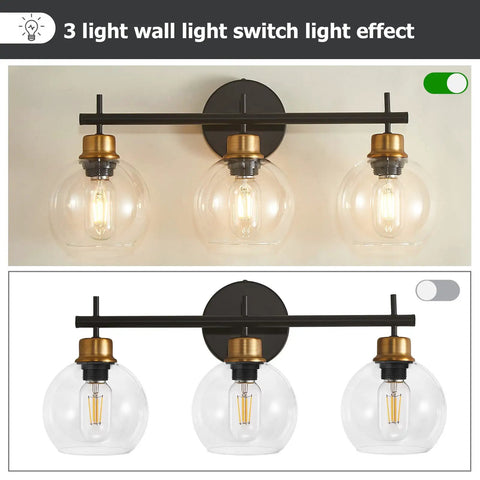 Three Light Black And Gold Bathroom Vanity Light Fixture With Metal Base And Clear Glass Globe Shades, Modern Over Mirror Bath Lighting That Elevates Your Space With Sleek Durable Build And High End Look illuminated and dimmed.