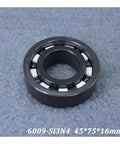 Top Tier Silicon Nitride Full Ceramic Ball Bearings Model 6009 With PTFE Cage And 45X75X16MM Specs shown from side on gray surface.