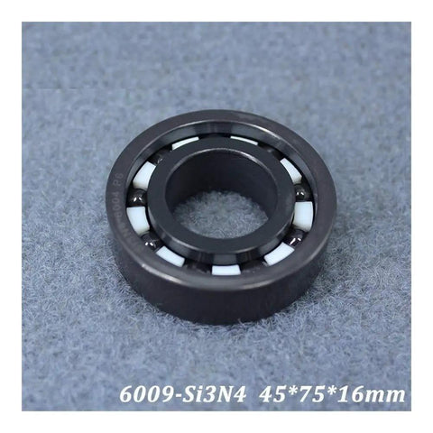 Top Tier Silicon Nitride Full Ceramic Ball Bearings Model 6009 With PTFE Cage And 45X75X16MM Specs shown from side on gray surface.