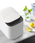 Self Cleaning Portable Countertop Ice Maker Spits Out Nine Bullet Cubes In Six Minutes With Smart Touch Panel And Two Liter Tank on a marble countertop.