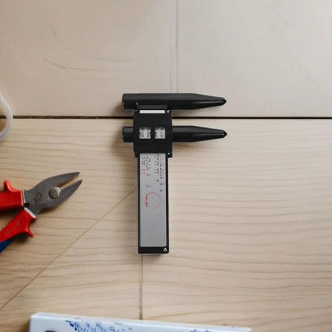 2pcs ABS Wheel Bolt Spacing Tool for Wheel Hub Precision Measurement on wood surface with pliers, showing precise measuring details.