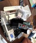 Hella Portable Handheld Inkjet Printer With Rechargeable Battery Tough Carry Case And Instant Print Setup For Quick Job Site Product Coding Marking And Shipping Label Jobs Anywhere positioned on a table with accessories.