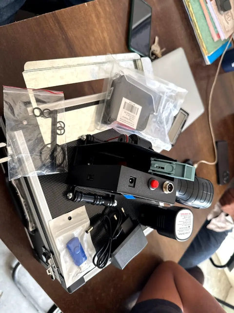 Hella Portable Handheld Inkjet Printer With Rechargeable Battery Tough Carry Case And Instant Print Setup For Quick Job Site Product Coding Marking And Shipping Label Jobs Anywhere positioned on a table with accessories.