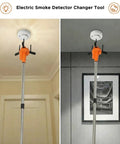 Zero Sweat Electric Smoke Detector Swap Tool Featuring Radio Controlled Expandable Silicone Grips And Adjustable Telescoping Handle in use on ceiling.