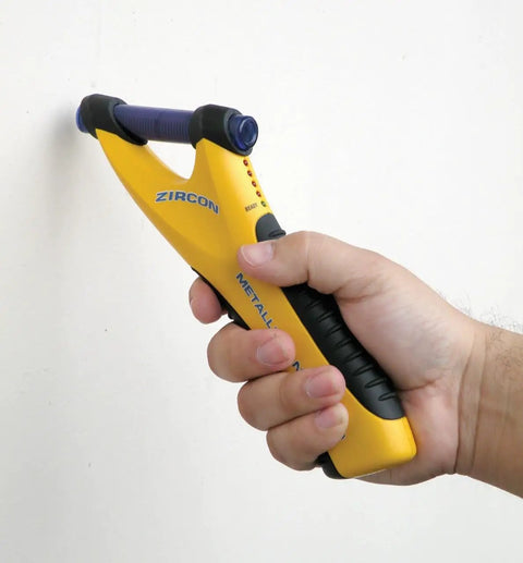 Person using MetalliScanner M40 Handheld Electronic Metal Detector on a wall for Drywall Concrete Lathe and Plaster Stucco detection.