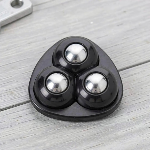 Mini Caster Wheels 12pcs 360 Degree Swivel Adhesive for Furniture, close-up of three black plastic ball casters on a light wood surface.