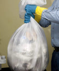 Hella Heavy Duty 60 Gallon Clear Trash Bags, 100 Count Bulk Pack, 38X58 Inch Size, 1.5 Mil Thickness being lifted from a bin.