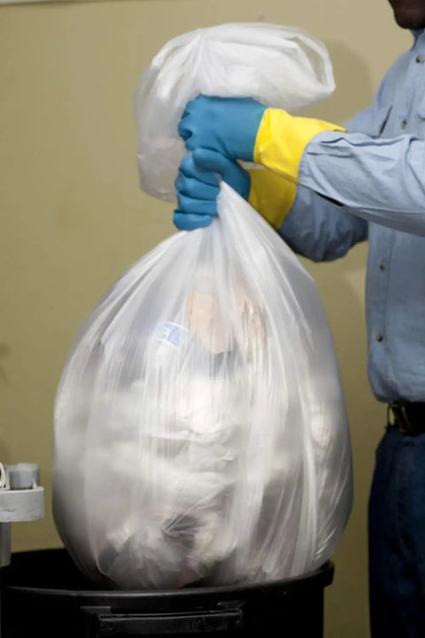 Hella Heavy Duty 60 Gallon Clear Trash Bags, 100 Count Bulk Pack, 38X58 Inch Size, 1.5 Mil Thickness being lifted from a bin.