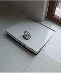 Built Tough Concealed Basement Floor Access Door With Large Suction Handle And Dual Hydraulic Struts on tiled surface.