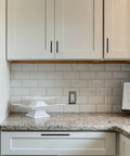 Matte black zinc alloy cabinet pulls installed on white kitchen cabinets showing 5 inch solid hardware in modern style.