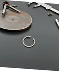 Stainless Steel C Clip from 5 Pack with Grooved Retaining Rings on dark surface, tools in background