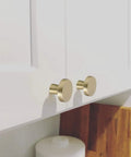 Gold Cabinet Knobs 5 Pack Sleek For Dresser Drawers And Kitchen Cabinets Brushed Brass Modern Round Zinc Alloy Hardware Handles Durable Zinc Alloy Knob Set Bundle installed on white cabinet doors.
