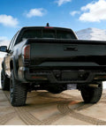 Black truck with Limited Edition American Flag Trailer Hitch Cover Honoring 250 Years Of Freedom in desert landscape.