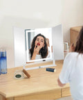 Vanity Tri Fold Makeup Mirror With 3 Lighting Modes Dimmable Smart Touch Control in use on tabletop with woman applying makeup.