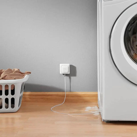 Smart WiFi Water Leak Detector With Real Time Text And Email Alerts, Audible Alarm, Geofencing, No Hub Needed beside a washing machine