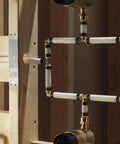 Installed brass PEX crimp fitting kit in use with visible straight, elbow, tee, and four-way fittings for plumbing connections