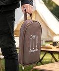 Person holding a brown kitchen set bag outdoors. Waterproof Camp Kitchen Knife Bag With Large Capacity Storage And Hooks.