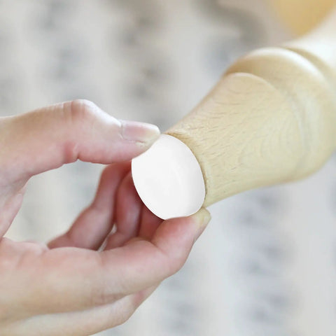 White Plastic And Iron Furniture Glides With Double Head Pins For Chairs And Furniture Feet being installed on wood furniture leg.