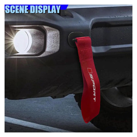Custom Red Deco Tow Strap For Car Bumper And Trunk, Stylish Trailer Belt Plus Towing Rope Auto Exterior Bling With Abs Hook, Personalized Racing Stripe Decor That Gives Your Whip Serious Street Cred mounted on a car bumper at night.