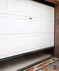 White garage door with installed Garage Door Threshold Seal Weather Stripping Bottom Rubber 20 Feet Long 3.15 Inch Wide.