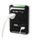 Three Outlet Travel Surge Protector With Two USB Ports, 540 Joules, mounted on wall with plugged cables