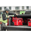 Professional Grade M18 Fuel Four Pack Cordless Power Tool Combo Kit featuring red tool boxes in a truck bed on a job site.