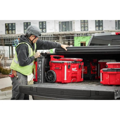 Professional Grade M18 Fuel Four Pack Cordless Power Tool Combo Kit featuring red tool boxes in a truck bed on a job site.