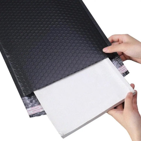 Five Pack Black Waterproof Bubble Mailers With Tear And Shake Resistant Envelope Bags For Shipping Jewelry Glass Art Photos And More Durable Protective Packaging For Mailing Supplies being opened by hands