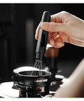 Professional Espresso Coffee Ground Distributor With 16 Stainless Steel Needles Magnetic Telescopic Stirrer in use for leveling coffee grounds.