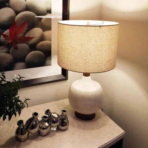 Stylish living room setting with decorative table lamp and modern decor accents next to framed artwork on a side table.