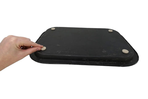 Hand placing Self Adhesive Felt Furniture Pads 3/4 Inch Beige 120 Pack on a black textured surface.