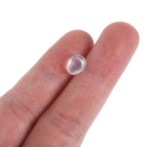 Push In Silicone Nose Pads For Glasses 50 Pack Non Slip Waterdrop Cushions Transparent Anti Sweat Replacement Inserts close-up on fingertip