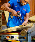 Man using Brushless Cordless Hammer Drill With Two 20 Volt Batteries And Active Hammer Action for wood drilling tasks.