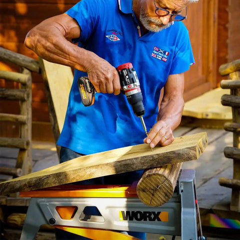 Man using Brushless Cordless Hammer Drill With Two 20 Volt Batteries And Active Hammer Action for wood drilling tasks.