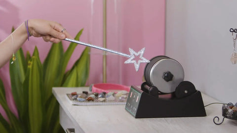 Person using a star wand with Advanced Rock Tumbler Kit With Digital Polishing Timer And Three Speed Settings on pink backdrop