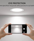 Hands holding a smartphone capturing 6 Pack 4 Inch Canless LED Recessed Lights With Junction Box, Ultra Thin 5000K Daylight on ceiling